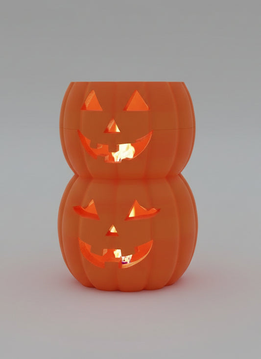 A stacked set of two orange jack-o'-lantern-shaped containers with carved faces, sitting on a dark shelf in front of a window.