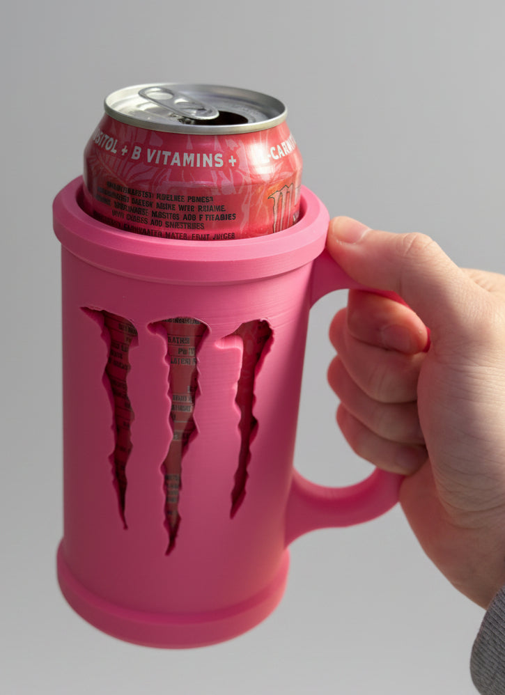 Pink can cooler holding a can of Red Bull on a wooden surface.