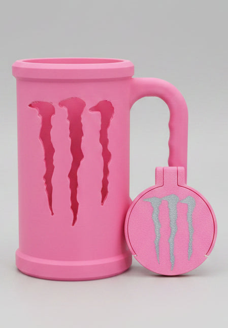 Pink mug and lid with Monster Energy logo on a wooden surface.